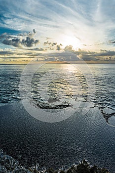 Rocks near the sea. Sunset sky reflected in the pools