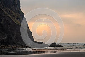 rocks and ocean with evening hazy sunset