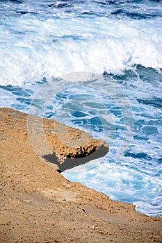 Rocks overhanging the sea at Marsalforn, Gozo.