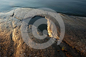 Rocks and puddle in the evening light at Lake MÃ¤laren, Viksberg, Sweden