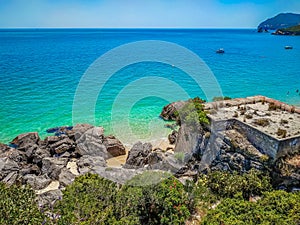 Rocks, ruins and bushes with turquoise water at Galapos Beach, ArrÃ¡bida - SetÃºbal PORTUGAL photo