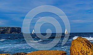 Rocks, sailing boats and ocean