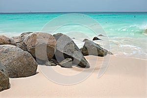 Rocks on a sandy beach on Aruba in the Caribbean Sea