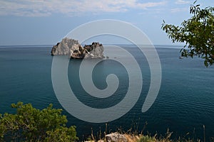 Rocks in the sea on the backgrounf of the blue cloudy sky photo