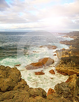 Rocks, sea waves and sunny sky