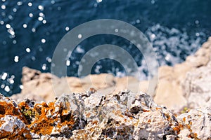 Rocks at seashore of Adriatic sea, Mediterranean, closeup. Aerial top view of sea waves hitting rocks on the beach.