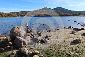 Rocks on the shore and mountain in the background in the Morales reservoir on the Ruta de los CastaÃÂ±os photo