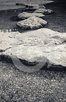 Rocks stones isolated in water in black and white, slovenia