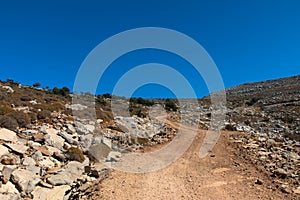 Rocks and stones on the off-road trail to the top of Attavyros mountain. Dry climate. Rhodes island, Greece.