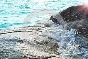 Rocks in tropical sea with gentle waves flowing through.