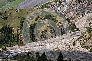 Rockslide in the mountains. Scenic background. Natural summer landscape. Beautiful mountains with landslide. Barskoon river valley