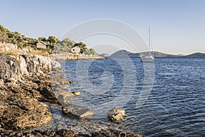 Rocky Adriatic coast near the fishing village at sunset in Croatia photo