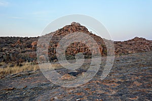 Rocky arid terrain with a small rocky hill. Desert landscape and nature