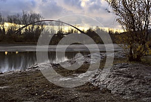 Rocky bank of the Ob River on the background of the bridge