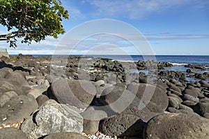 Rocky beach of Albion in Mauritius with cloudy sky background.