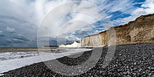 Rocky beach at Birling Gap with the cliffs of the Seven Sisters in the background on the Jurassic Coast of East Sussex