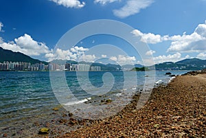 Rocky beach with building, cloud and blue sky