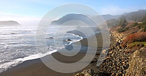 A rocky beach with a large body of water in the background