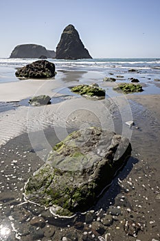 A rocky beach with a large rock in the foreground