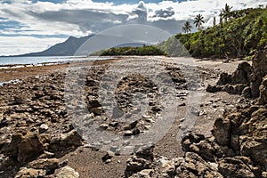 Rocky beach near Plum on New Caledonia coast with Mont Dore mountain in background