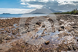 Rocky beach near Plum in New Caledonia with Mont-Dore mountain