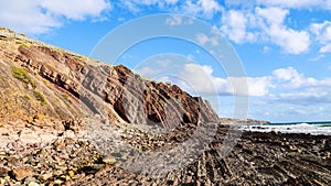 A rocky beach with rough cliffs and terrain at the sea on a sunny day in Hallet Cove, Australia