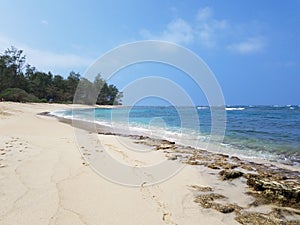 Rocky beach with Shallow wavy ocean waters of Camp Mokuleia Beach