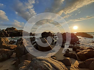 Rocky beach sunset under clouds