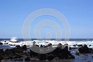 Rocky, black lava shoreline fronting deep blue Pacific Ocean at Laupahoehoe Point in Hawaii