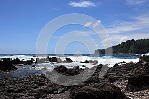 Rocky, black lava shoreline fronting deep blue Pacific Ocean at Laupahoehoe Point in Hawaii