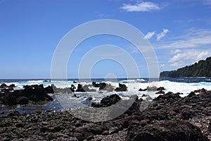 Rocky, black lava shoreline fronting deep blue Pacific Ocean at Laupahoehoe Point in Hawaii