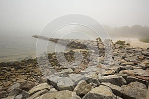 Rocky breakwater along a foggy beach in Niantic, Connecticut