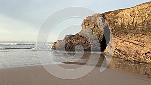 A rocky cliff with a cave in it. Cathedrals Beach.