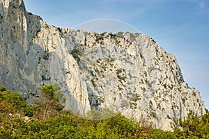 Rocky cliff of gray stone against blue sky