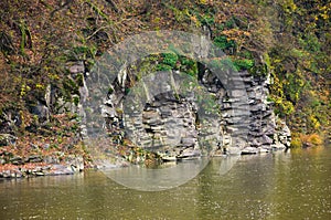 Rocky cliff over the river in forest