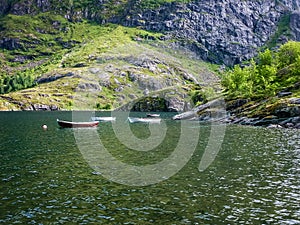 The rocky coast of the fjord of Norway. Fishing boats near the shore