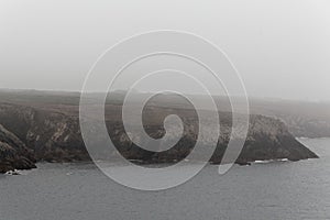 Rocky coast of the island Ouessant, in the fog