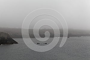 Rocky coast of the island Ouessant, in the fog