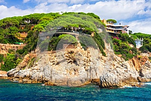 Rocky coast landscape in mediterranean with modern beautiful house on high sea shore in Costa Brava, Spain photo