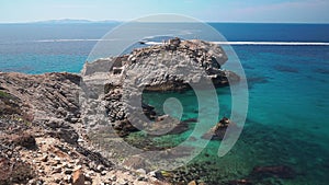 Rocky coast line of Mykonos Island, Greece. Speedboat on the background.