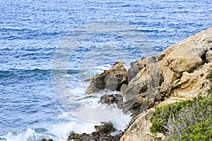 The rocky coast of the Mediterranean sea during an afternoon surf. Background