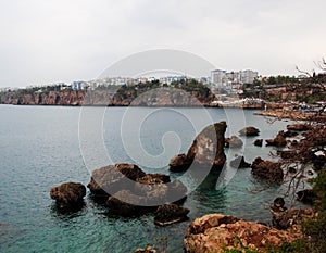 The rocky coast of the Mediterranean Sea. There are hotels on the shore. Antalya, Turkey, April 6, 2019