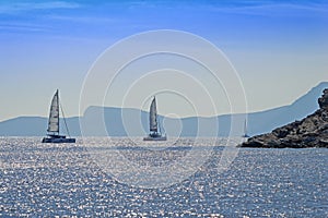 Rocky coast and sailing catamarans, Aegean sea