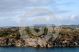 Rocky coast of Scandinavia with houses on a northern summer day