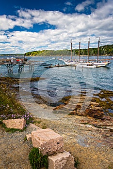 Rocky coast and view of boats in the harbor at Bar Harbor, Maine