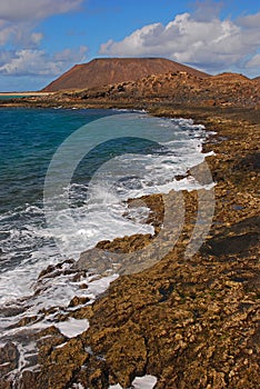 Rocky coastal beach & waves of Lobos Island, locally known as Isla de Lobos, 2 kilometres north of Fuerteventura island, Spain