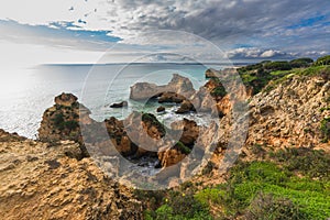 Rocky coastline in Algarve, Portugal, and dramatic cloudy sky