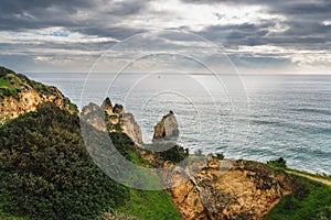 Rocky coastline in Algarve, Portugal, and dramatic cloudy sky