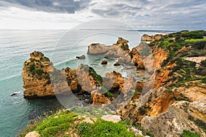 Rocky coastline in Algarve, Portugal, and dramatic cloudy sky