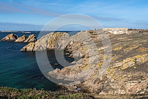 The rocky coastline of Beg er Vachif peninsula in west of Houat island in French Brittany. Ruins of Beniguet bastion are at right